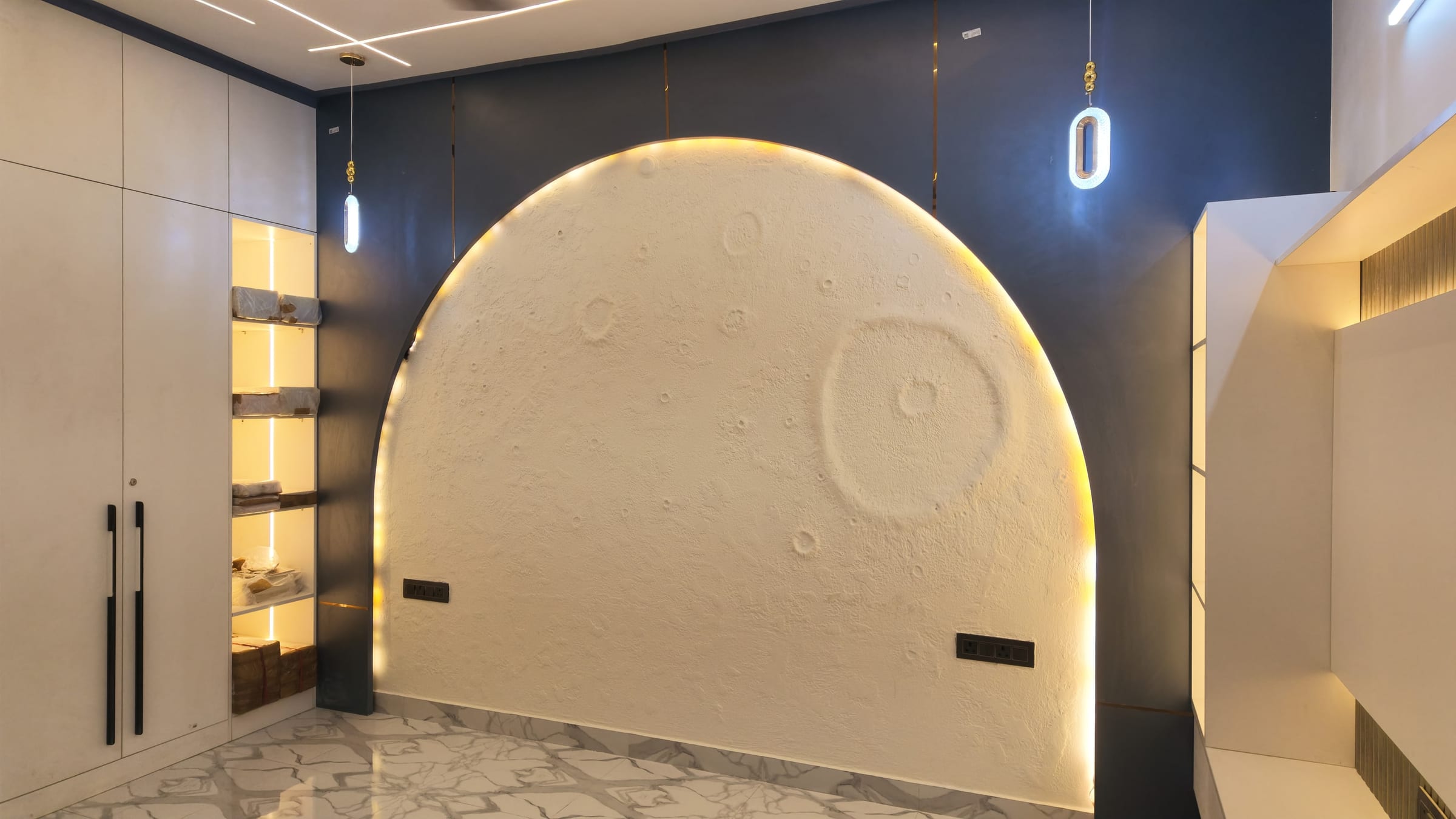 The finished arched feature wall in textured cream against a deep navy wall, lit from behind, with the white wardrobe run to its left